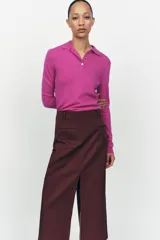 Jersey de lana color fucsia con cuello polo y tapeta con botones.