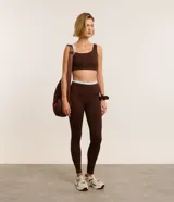 Conjunto deportivo color marrón chocolate, compuesto por un top con breteles finos y calzas largas de tiro alto.