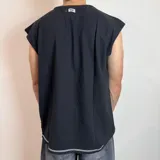 Musculosa blanca de corte holgado con costuras a la vista en cuello, sisas y centro.