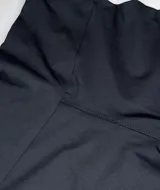 Calza biker negra con cintura alta y logo blanco en la pierna izquierda.