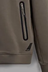 Sudadera con capucha color marrón topo, de corte regular fit, confeccionada en tejido técnico compacto de algodón con elasticidad. Cuenta con cuello subido, manga larga con bolsillo, bolsillos frontales con cierre de cremallera y acabados con rib del mismo tejido.
