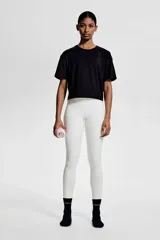 Remera deportiva corta de corte holgado, color negro, con cuello redondo y mangas cortas con hombros caídos.