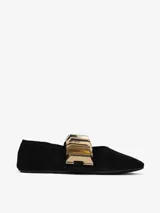 Zapato plano negro de tela con punta fina y aplique metálico dorado en el empeine.
