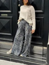 Sweater color beige con cuello redondo y diseño de trenzas en relieve.