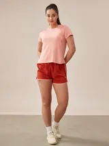 Remera de poliéster color coral, de corte clásico y mangas cortas.