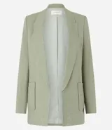 Blazer largo color beige confeccionado en viscosa y lino, con cuello solapa, bolsillos y forro estampado a rayas.