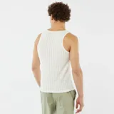 Musculosa blanca de tejido calado con cuello redondo y sisas amplias.