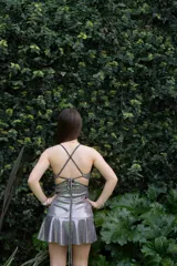 Vestido corto de lentejuelas color verde oliva, con escote en V, breteles finos cruzados en la espalda, cut-outs laterales y volado en el ruedo.