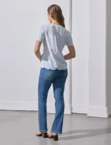 Blusa celeste de algodón con bordado broderie, cuello a la base con abertura central y botones.