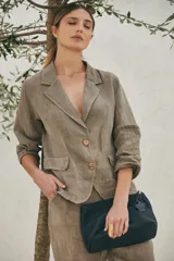 Neceser de cuero marrón con cierre superior y tirador de cuero con flecos.