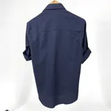 Camisa de algodón a cuadrillé chico azul marino, con cuello italiano y mangas largas con puño abotonado.