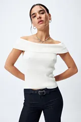 Top tejido color blanco con escote bardot que deja los hombros al descubierto y punto acanalado.