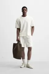 Bermuda negra de corte relaxed fit, con cintura elástica ajustable con cordón, bolsillos frontales y bolsillo trasero de parche.