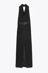 Vestido largo negro con cuello halter y escote fluido, hombros descubiertos, detalle de drapeado en los laterales, forro interior a tono, bajo con abertura en la espalda y cierre lateral con cremallera oculta y botones en el cuello.