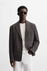Blazer marrón con estampado pata de gallo, de corte regular fit, con cuello de solapas de muesca, manga larga con puños abotonados, bolsillo de vivo en el pecho, bolsillos de solapa en la cadera, bolsillo interior, aberturas en la espalda y cierre frontal con botones.