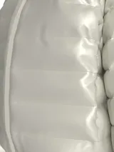 Campera puffer corta color blanco, confeccionada en nailon reciclado con acabado brillante. Tiene cuello alto, cierre frontal con cremallera, bolsillos laterales con cremallera y logo de Calvin Klein en el pecho.