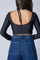 Top negro de escote redondo y espalda baja, confeccionado con tejido elástico regenerado a partir de desechos de nylon reciclados.