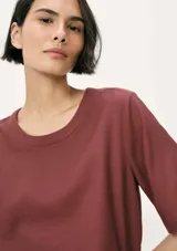 Blusa color beige de lino con mangas cortas y cuello redondo.