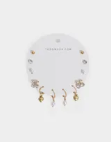 Set de seis pares de aros dorados con diferentes diseños: bolitas, cerezas con strass, strass solitarios, perlas colgantes y corazones colgantes.
