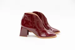 Botinetas plateadas de cuero con punta fina y taco geométrico.