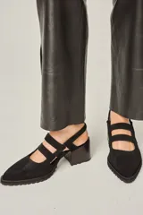 Zapato marrón de cuero con punta fina, taco de madera y tiras cruzadas.