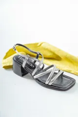 Sandalias de cuero plateadas con tiras finas cruzadas y taco bloque bajo.