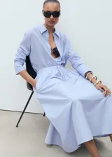 Falda larga color celeste claro, de tejido de algodón, con cintura elástica ajustable mediante cordón y bolsillos laterales.