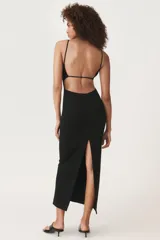 Vestido midi negro de breteles finos, escote recto y falda ajustada con abertura lateral.