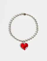 Collar plateado con cadena de bolitas y dije de corazón rojo transparente.