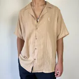 Camisa color beige de muselina con manga corta y corte oversize.