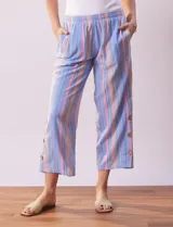 Pantalón capri de algodón estampado a rayas verticales en tonos celeste, rosa y beige. Tiene pretina elastizada, bolsillos delanteros y tajos laterales con botones.