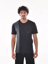 Remera negra de corte oversized con bolsillo en el pecho y detalle de bloque gris en el lateral.