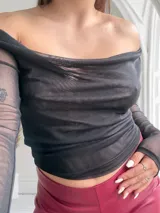 Top negro de tul con escote bardot y mangas largas.