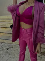 Blazer rosa forrado con mangas 3/4 y detalle de plumas en los puños. Tiene solapas y bolsillos frontales.