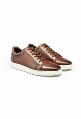 Championes de cuero color marrón con suela blanca y cordones marrones.