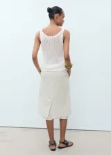 Top blanco de punto calado, sin mangas y con cuello redondo.