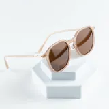 Lentes de sol con montura geométrica color rosa pálido y lentes marrones con protección UV400.
