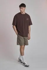 Remera marrón de corte holgado con estampado pequeño en el pecho.