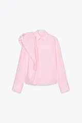 Camisa de popelín rosa de algodón, con cuello solapa, manga larga con puños plisados y volumen en un hombro. Cierre frontal con botones ocultos.