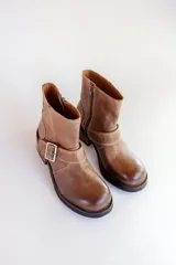 Bota corta color marrón de cuero, con hebilla metálica y taco de madera.