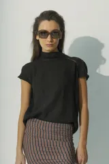 Blusa negra de lino con cuello alto y mangas cortas con detalle de calado en los hombros.