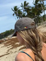 Gorra de béisbol color marrón con bordado frontal de la palabra "MILO" en color dorado.
