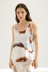 Musculosa blanca con estampado abstracto en tonos marrones y celestes, con cuello redondo y sisas con ribete en color crudo.
