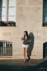 Shorts blancos con lunares negros, de tiro medio con trabillas, bolsillos laterales y falsos bolsillos de vivo en la espalda.