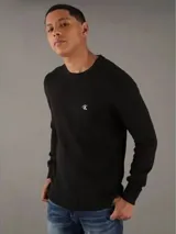 Sweater de punto negro con cuello redondo y logo de la marca bordado en el pecho.