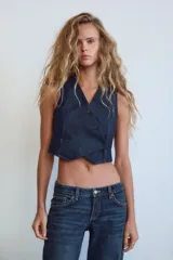 Jeans de mezclilla azul oscuro con efecto lavado, tiro bajo y pierna ancha extra larga. Modelo de cinco bolsillos con cierre frontal de cremallera y botón metálico.