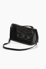 Cartera bandolera chica de rafia trenzada color negro, con forro interior, cierre superior y correa ajustable de cuero sintético.