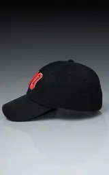 Gorra de gabardina negra con visera curva y ajuste trasero de velcro. Presenta un bordado frontal con el número "90" en color rojo con borde blanco.