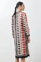 Vestido camisero midi con estampado abstracto en tonos beige, rojo y negro.