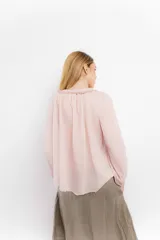 Blusa rosa de algodón con escote en V con cordones y detalle de volados.